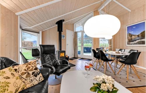 a living room with black leather chairs and a table at Holiday Home Toften Hadsund V in Nørre Hurup