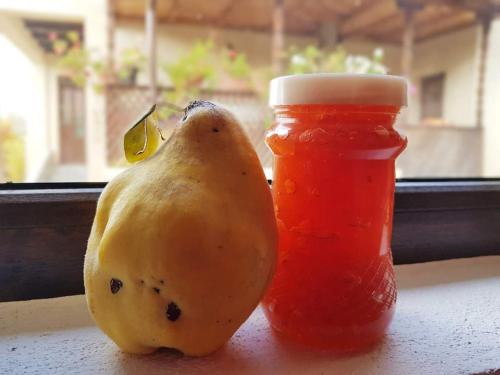 a yellow pear next to a jar of jam and a bottle at Casa Smeilor Horezu in Horezu