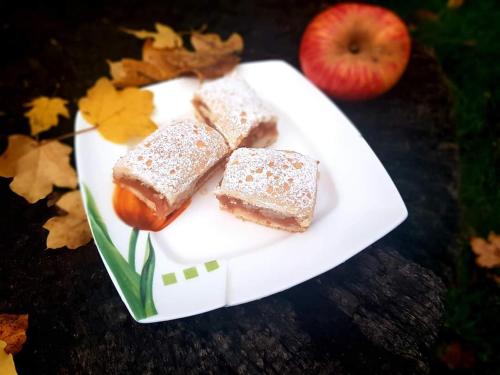 a white plate with two pieces of bread and an apple at Casa Smeilor Horezu in Horezu