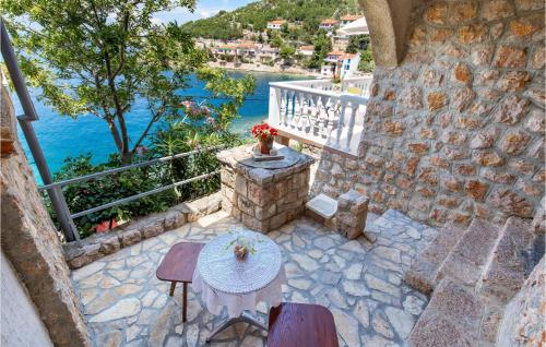 a patio with a table and a balcony with the water at Stunning Apartment In Senj With Kitchen in Starigrad