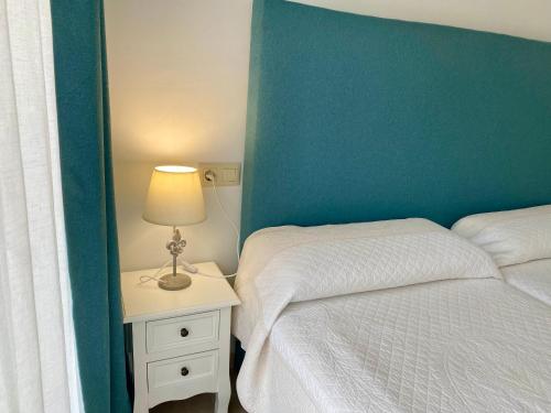 a bedroom with a bed and a table with a lamp at Ideal house at the Beach in Sagunto(Valencia) in Sagunto
