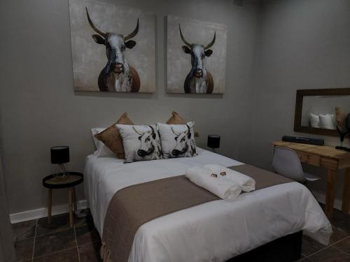 a bedroom with a bed with two deer heads on the wall at The Honeycomb 2 in Kimberley
