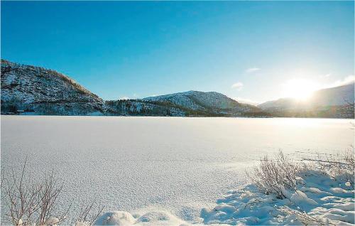 a snow covered lake with the sun in the background at Holiday Home Tysse Eikedal in Kleivi