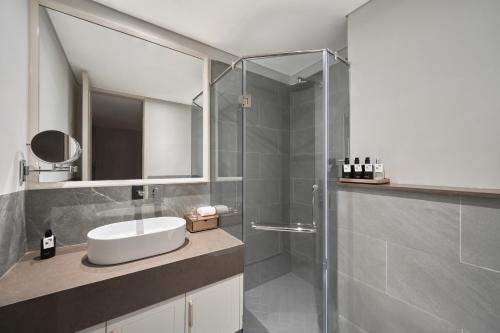 a bathroom with a sink and a shower at Epic Tower Swiss-Belresidences Hanoi in Hanoi