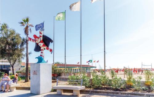 a park with a bench and flags in the background at Casa Di Giulio in Massaciuccoli