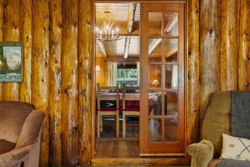 a living room with wooden walls and a dining room at White Pass Log Cabin Luxury Retreat in Rimrock