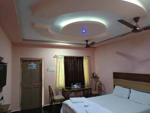 a bedroom with a bed and a ceiling at Sri Murugan Beach Paradise Hotel in Mahabalipuram