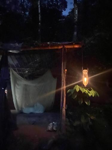 a lantern hanging from a house at night with a boat at TheJungleGuide - Lodges & Treks in Bukit Lawang