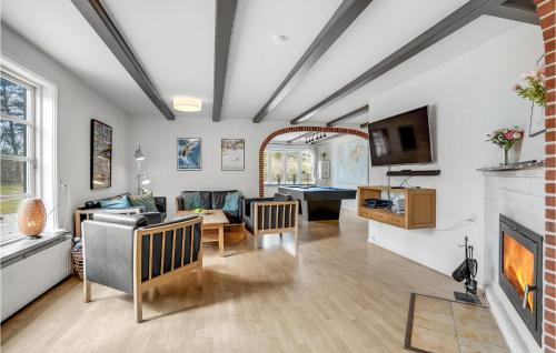 a living room with a couch and a fireplace at Amazing Home In Væggerløse With Sauna in Marielyst