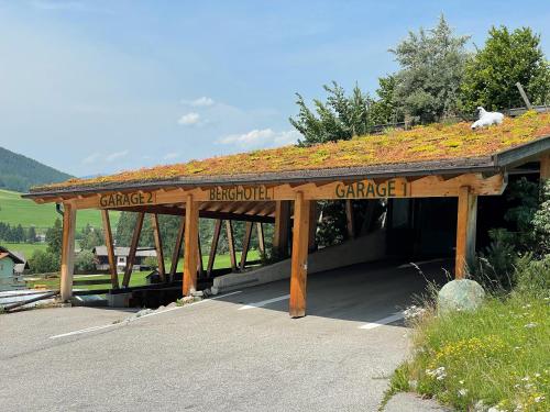 a wooden pavilion with a dog sitting on top of it at Berghotel - Sexten in Sesto