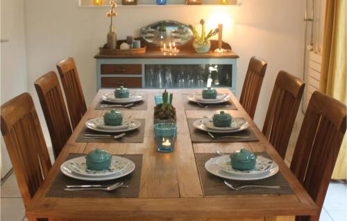 a wooden table with chairs and a long table with green dishes at Fonteinbos in Oudemirdum