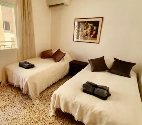 two beds in a room with two bags on them at La casa de Pernilla Awesome apartment, near beach in centre of town in Puerto de Mazarrón
