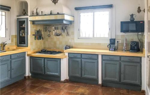 une cuisine avec des armoires bleues et un comptoir dans l'établissement Stunning Home In L, Adrets De Lesterel, à Les Adrets-de-l'Estérel