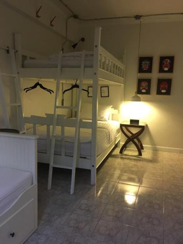 a bedroom with two bunk beds and a lamp at Bed in Town in Chiang Mai