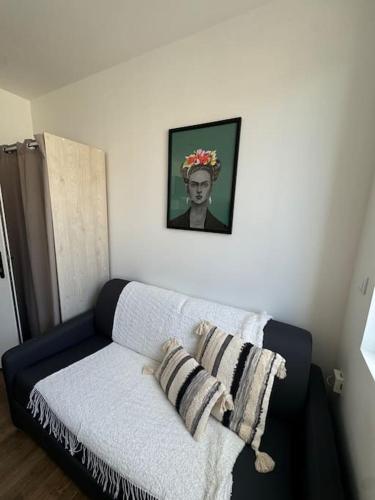 un canapé dans une pièce avec une photo d'un homme dans l'établissement Studio cosy - Hyper centre, à Valenciennes