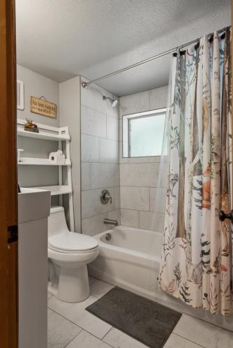 a bathroom with a toilet and a shower curtain at White Pass Log Cabin Luxury Retreat in Rimrock
