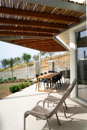 a patio with a table and chairs under awning at Physis Fokida in Eratini