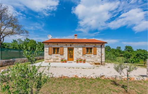 a small stone house with a red roof at Beautiful Home In Zminj With Kitchen in Žminj