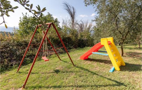 two childrens play equipment in the grass at Casa La Coccinella in Nestore