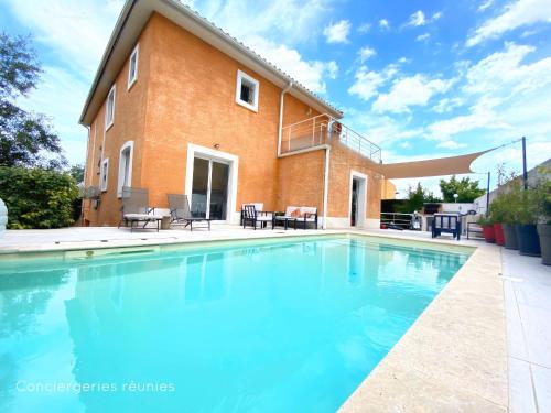 une grande piscine devant une maison dans l'établissement Côté sud - spacieuse et lumineuse villa, à Les Matelles