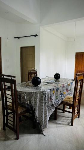 a dining room table with two black bowls on it at Gagana Vila in Kandy