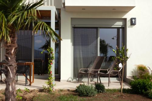 a pair of chairs sitting on a patio outside of a house at Physis Fokida in Eratini