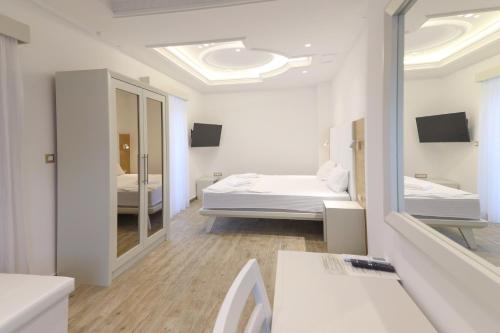 a white room with two beds and a mirror at Hotel RR in Herceg-Novi