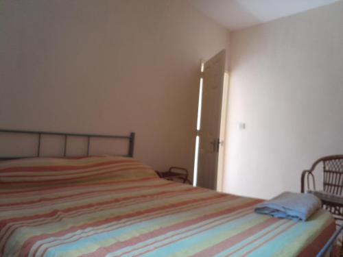 a bedroom with a bed with a striped blanket at Chetty Tourist Residence in Pereybere