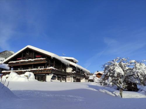 a building covered in snow in front at Der Sonnenhof - Ferienwohnungen in Obermaiselstein