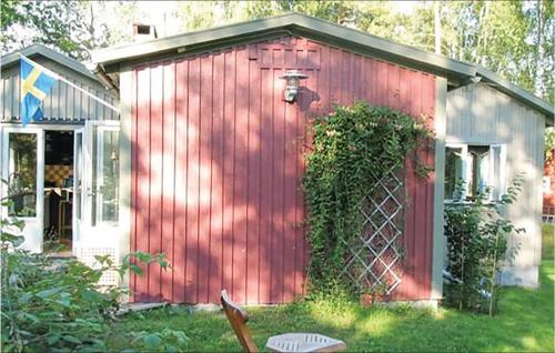 a red shed with a red door in a yard at 3 Bedroom Beautiful Home In Trosa in Trosa
