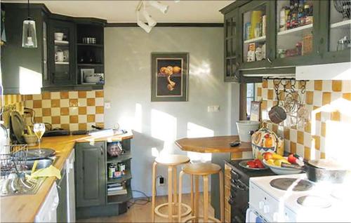 a kitchen with green cabinets and a counter with stools at 3 Bedroom Beautiful Home In Trosa in Trosa