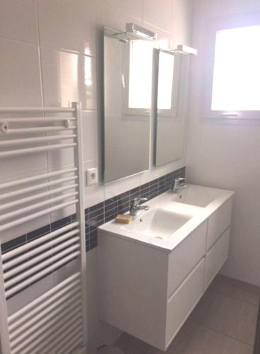a white bathroom with a sink and a mirror at Villa Sanguinet proche Bassin d Arcachon in Sanguinet