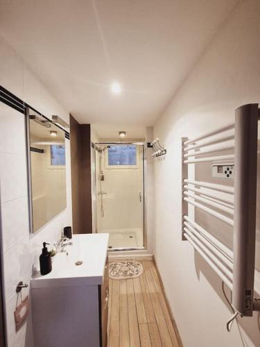 une salle de bain blanche avec un lavabo et une douche dans l'établissement T2 Havre de paix nature cœur d Aix, à Aix-en-Provence