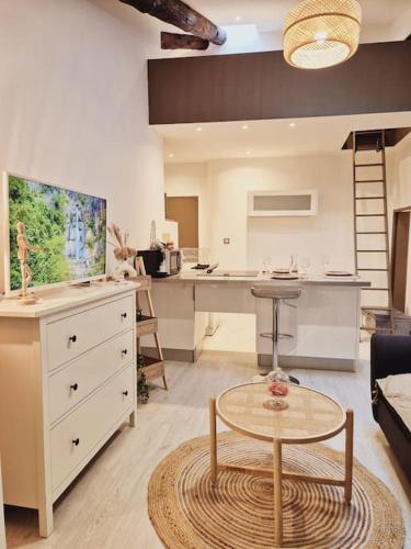 un salon avec une table et une cuisine dans l'établissement T2 Havre de paix nature cœur d Aix, à Aix-en-Provence