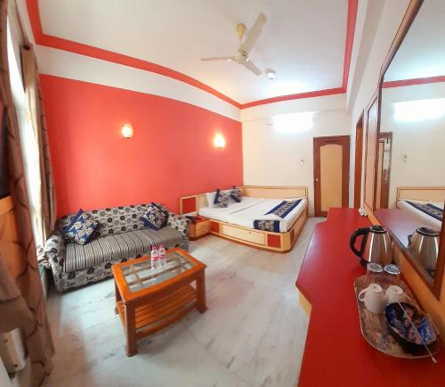 a living room with two beds and a couch at Hotel Indore Palace - Newly Renovated Hotel in Shirdi