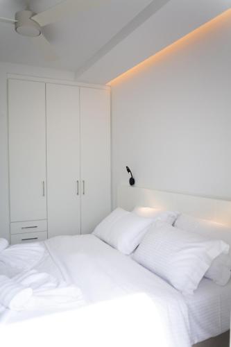 a white bed with white sheets and pillows at Physis Fokida in Eratini