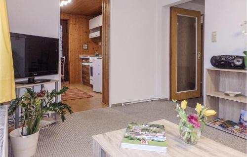 a living room with a tv and a table at 1 Bedroom Cozy Apartment In Marlow in Blankenhagen
