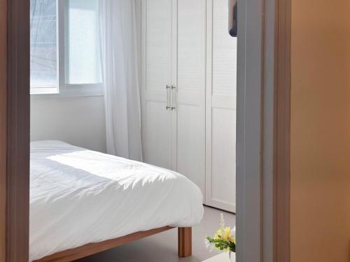 Un dormitorio con una cama blanca y una ventana. en Wellness Stay, en Seúl