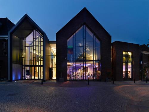 a building with large glass windows in front of it at Hotel de Landmarke by Flow in Groot-Agelo