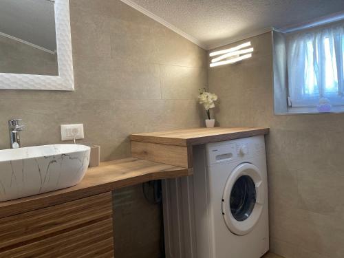 a bathroom with a washing machine and a sink at Apartments Dora in Poreč