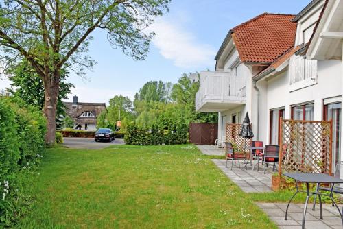 a yard with chairs and a table next to a house at Kleine Ferienwohnung mit Terrasse und Gartenblick in Gustow