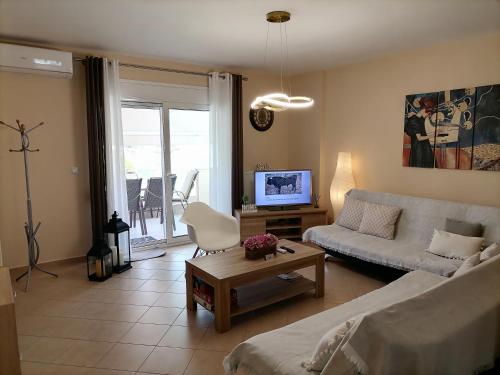 ネア・ペラモスにあるBella Casaのソファとテレビのあるリビングルーム