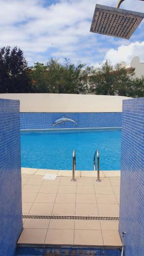 une piscine d'eau bleue en arrière-plan dans l'établissement Studio Port Jo CLIM WIFI Garage et Piscine au Couchant 3pers - ROSSIconciergerie - Linge inclus, à La Grande Motte