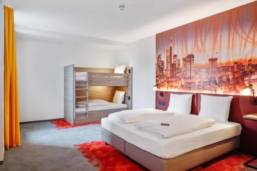 a bedroom with a bed and a large painting on the wall at Campanile Frankfurt Offenbach in Offenbach