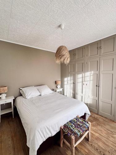 - une chambre avec un grand lit et un pendentif dans l'établissement Maison les Flots dot Fr, à Denneville