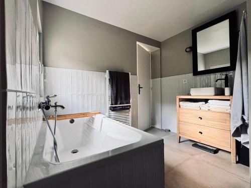 La salle de bains est pourvue d'une grande baignoire et d'un lavabo. dans l'établissement Maison les Flots dot Fr, à Denneville