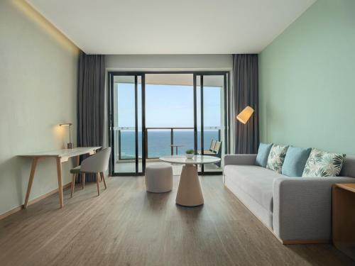 a living room with a couch and a table at Element Yangjiang Hailing Island in Yangjiang