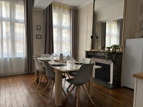 une salle à manger avec une table, des chaises et un miroir dans l'établissement La Salle d Attente - Hyper centre, à Châlons-en-Champagne
