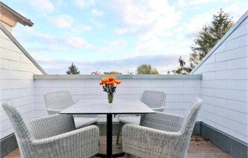 a table with chairs and a vase of flowers on a patio at Baltischer Hof Apartment 65 in Boltenhagen