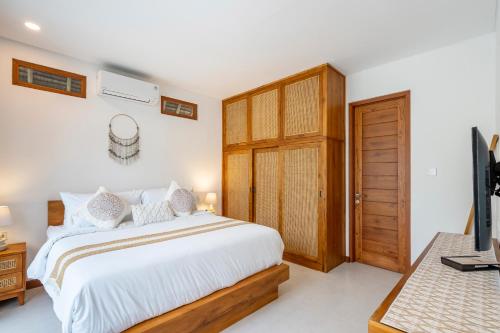 a bedroom with a bed and a wooden door at Villa Asri Nusa Dua in Nusa Dua